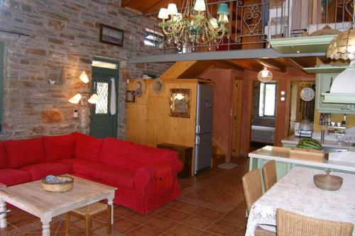 a living room with a red couch and a kitchen at villapetramarina in Tsakaíoi