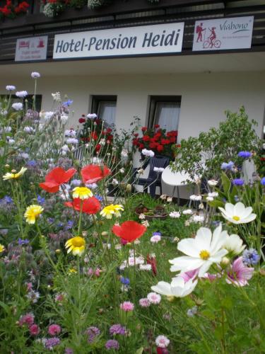 a garden of flowers in front of a hotel pensionership at Hotel Pension Heidi in Dobel