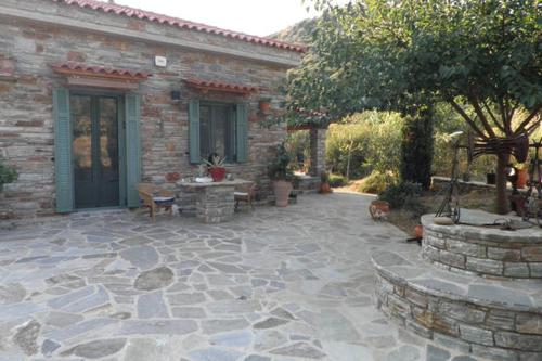 a patio in front of a brick house with a table at villapetramarina in Tsakaíoi