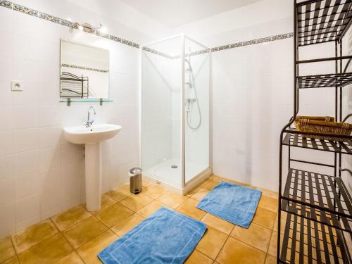 une salle de bain avec un lavabo et une douche et deux tapis bleus dans l'établissement Holiday Home in Montclus by Lavender Fields, cleaning included, à Montclus