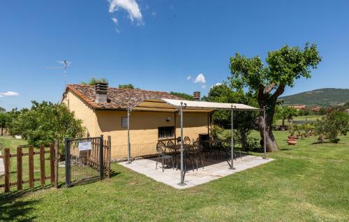 ein Haus mit einem Tisch und Stühlen unter einem Sonnenschirm in der Unterkunft Pet Friendly Home In Cortona With Wifi in Cortona