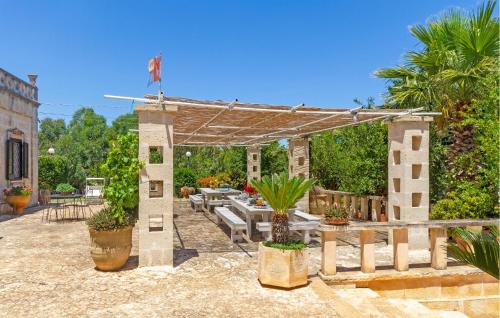 un patio con pérgola, mesas y plantas en Casal Del Borgo 7, en Ostuni
