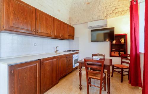 una cocina con armarios de madera y una mesa con fregadero en Casal Del Borgo 7, en Ostuni