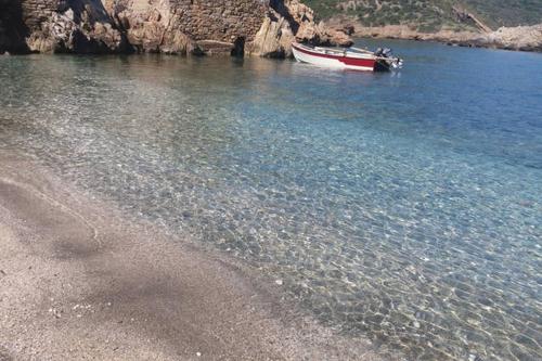 a boat in the water next to a beach at villapetramarina in Tsakaíoi