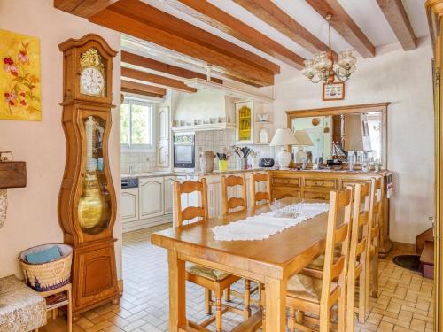 une cuisine avec une table en bois et une horloge dans l'établissement Holiday Home Pénestin near Beach, cleaning included, à Pénestin