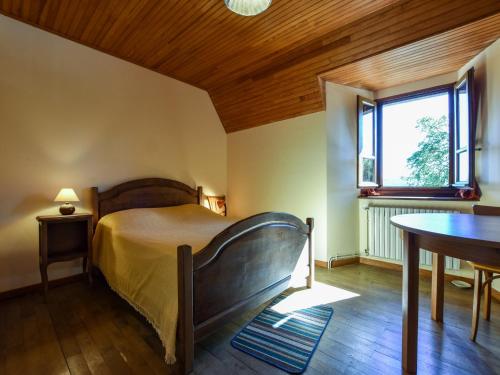 une chambre avec un lit, une table et une fenêtre dans l'établissement Holiday Home in Oradour with Terrace, cleaning included, à Neuvéglise