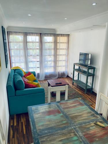 a living room with a blue couch and a table at THE HEIRS Departamentos in Posadas