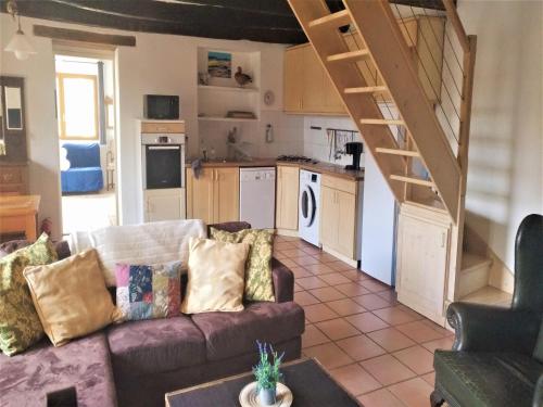 un salon avec un canapé et une cuisine dans l'établissement Holiday Home in Auriac with Private Pool, cleaning included, à Auriac