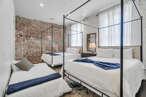 新奥尔良Charming Cbd 4br On Gravier Near Jazz & Dining的一间卧室设有两张床和砖墙