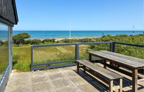 a wooden bench sitting on a balcony overlooking the beach at Stunning Home In Vejby With Sauna in Vejby
