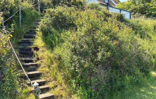 a set of stairs leading up a hill with flowers at Stunning Home In Vejby With Sauna in Vejby