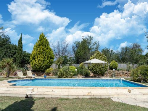 - une piscine dans une cour avec des arbres et des buissons dans l'établissement Villa in France with Pool and Vineyards, cleaning included, à Puisserguier
