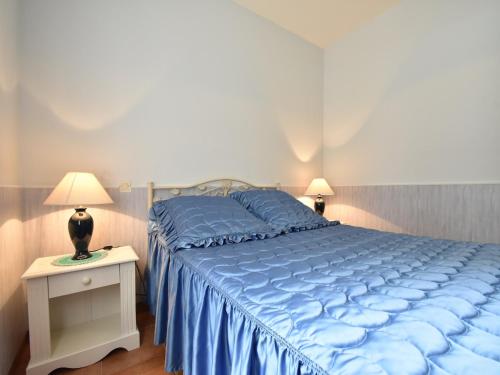 une chambre avec un lit bleu et une table de nuit avec une lampe dans l'établissement Holiday Home in Faverolles with Heated Pool, cleaning included, à Les Pégués