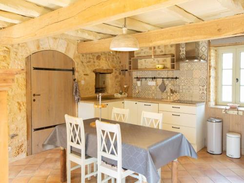 une cuisine avec une table et des chaises dans une pièce dans l'établissement Holiday Home in Loubejac with Bubble Bath, cleaning included, à Loubejac