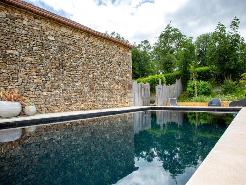 - une piscine en face d'un mur de briques dans l'établissement Holiday Home in Loubejac with Bubble Bath, cleaning included, à Loubejac