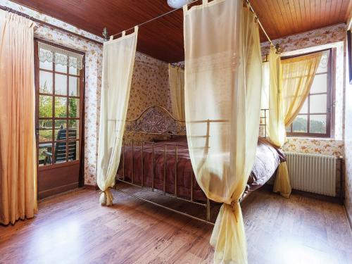 - une chambre avec un lit à baldaquin et des fenêtres dans l'établissement Holiday Home in Puy-l'Evêque with Pool, cleaning included, à Puy-lʼÉvêque