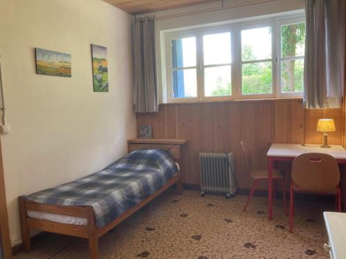 une chambre avec un lit, un bureau et une fenêtre dans l'établissement Apartment in Cuzy with Heated Pool, cleaning included, à Cuzy