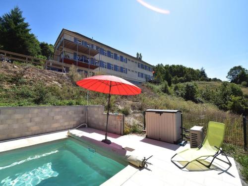 - une piscine avec un parasol rouge, 2 chaises et une table avec un parasol dans l'établissement Apartment in Cuzy with Heated Pool, cleaning included, à Cuzy