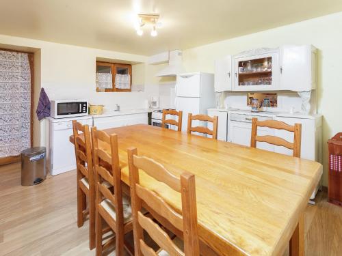 une cuisine avec une table et des chaises en bois dans l'établissement Holiday Home in Calvinet near Conques, cleaning included, à Calvinet