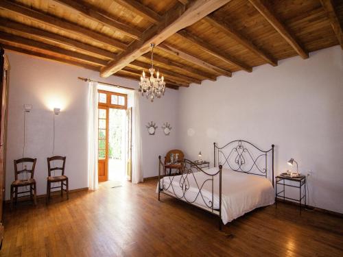 une chambre avec un lit et des chaises dans une pièce dans l'établissement Mansion in Sigoulès with Private Pool, cleaning included, à Sigoulès