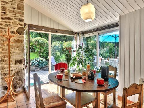 une salle à manger avec une table et des chaises ainsi qu'une grande fenêtre dans l'établissement Charming Stone House with Garden in Brittany, cleaning included, à Huelgoat