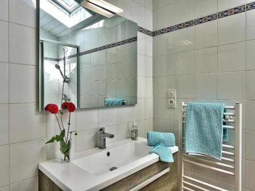 une salle de bain blanche avec un lavabo et un miroir dans l'établissement Charming Stone House with Garden in Brittany, cleaning included, à Huelgoat