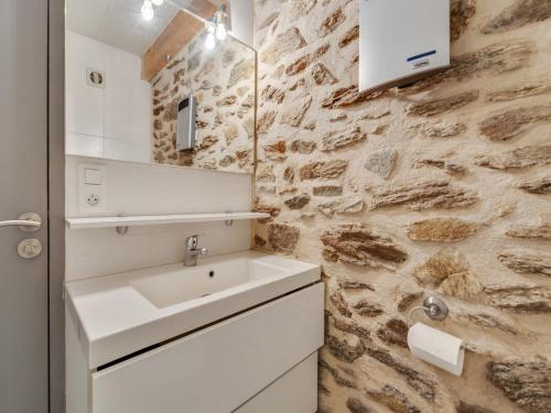 une salle de bain avec un lavabo et un mur en pierre dans l'établissement Holiday Home in Auvergne near Lespinasse Castle, cleaning included, à Saint-Beauzire