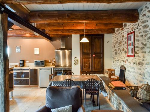 une cuisine avec une table et des chaises dans une pièce dans l'établissement Holiday Home in Auvergne near Lespinasse Castle, cleaning included, à Saint-Beauzire