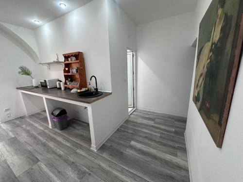 a white desk in a room with a wooden floor at Ultra Central Piata Libertatii Apartment in Timişoara