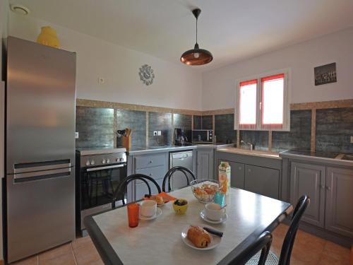 une cuisine avec une table et un réfrigérateur en acier inoxydable dans l'établissement Luxury Villa with Private Pool in Saint Victor de Malcap, à Saint-Victor-de-Malcap