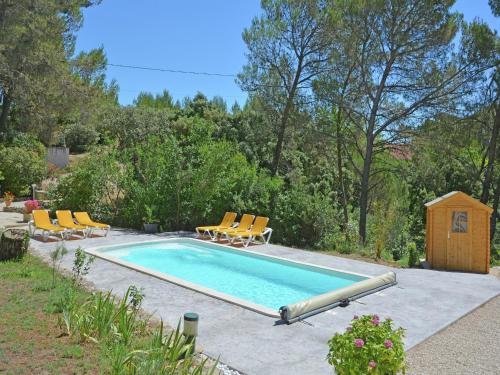 - une piscine avec des chaises et une cabane pour chiens dans l'établissement Mansion in Beaucaire with Private Pool, cleaning included, à Beaucaire