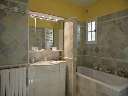 une salle de bain avec un lavabo, une baignoire et un miroir dans l'établissement Mansion in Beaucaire with Private Pool, cleaning included, à Beaucaire