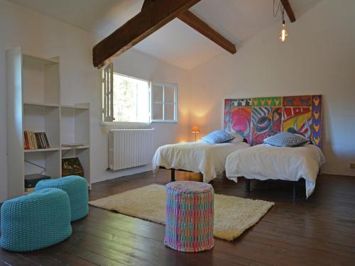 une chambre avec deux lits et une table et des chaises dans l'établissement Mansion in Beaucaire with Private Pool, cleaning included, à Beaucaire