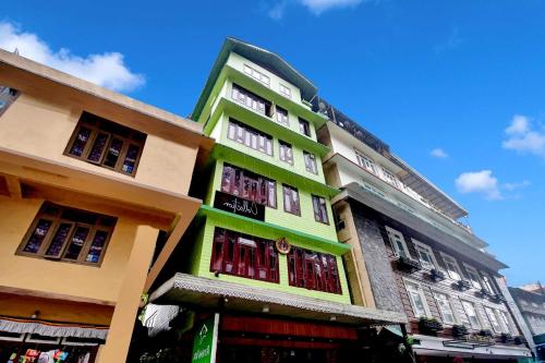 a green building with windows on the side of it at Hotel O Parasol Inn Gangtok in Gangtok