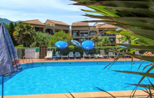 une grande piscine bleue avec chaises et parasols dans l'établissement Gorgeous Apartment In Moriani Plage, à San-Nicolao