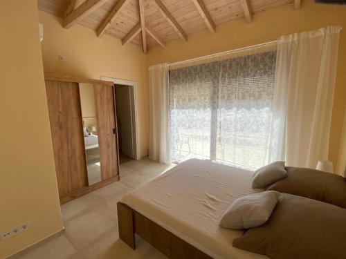 a bedroom with a bed and a large window at Villa Sunrise in Chrisokellaria