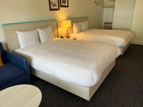 a hotel room with two beds and a blue chair at Revelstoke Lodge in Revelstoke