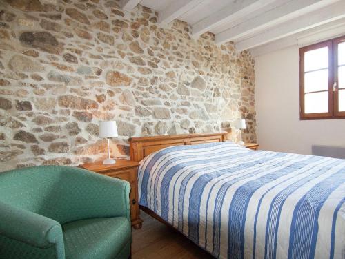 - une chambre avec un lit, une chaise et un mur en pierre dans l'établissement Cottage in France with Private Terrace, cleaning included, à Roussines