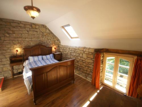 une chambre avec un lit et un mur en pierre dans l'établissement Holiday Home in Saizy with Stargazing Garden, cleaning included, 