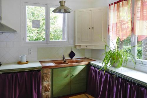 une cuisine avec un évier et deux fenêtres dans l'établissement Holiday Home in Denneville near Sandy Beach, cleaning included, à Denneville