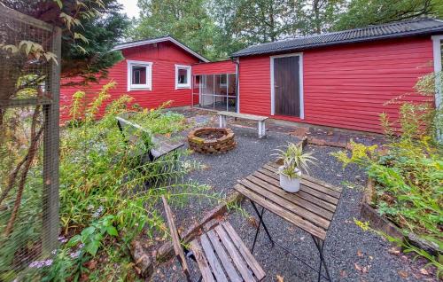 a red house with a bench in front of it at 2 Bedroom Amazing Home In Örkelljunga in Orkelljunga