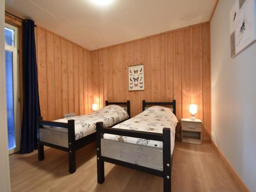 - 2 lits dans une chambre dotée de murs lambrissés dans l'établissement Mansion in Cuzy with Pool & Forest Views, cleaning included, à Cuzy