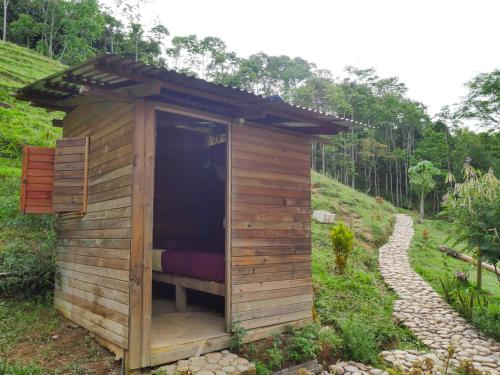 a small wooden shed with a red bed in it at Hostal El Silencio Vivo in San Rafael