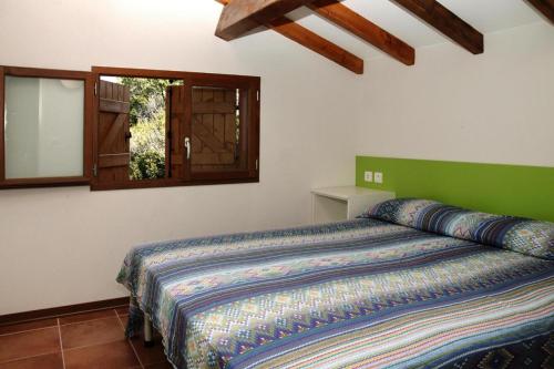 - une chambre avec un lit doté d'une tête de lit verte et d'une fenêtre dans l'établissement Apartment near Pinarellu Bay Beach, cleaning included, à Vardiola
