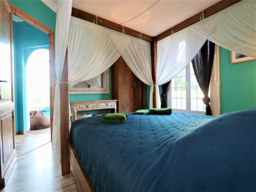 - une chambre dotée d'un lit bleu avec des oreillers verts dans l'établissement Villa in Lacanau-Océan near Beach, cleaning included, à Lacanau