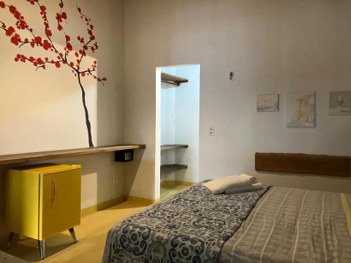 um quarto com uma cama e um vaso na parede em Vila Goa em Cruz