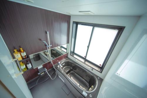 a small bathroom with a sink and a window at Churaumi Village Motobu-Fuji-Karst in Motobu