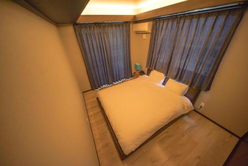 a small bedroom with a bed and a window at Churaumi Village Motobu-Fuji-Karst in Motobu