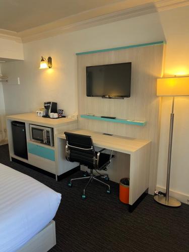 a hotel room with a desk and a bed at Revelstoke Lodge in Revelstoke