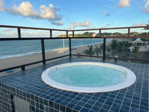 a hot tub on a balcony with a view of the beach at Flat completo a beira mar com vista exuberante - pé-na-areia mesmo! in Natal